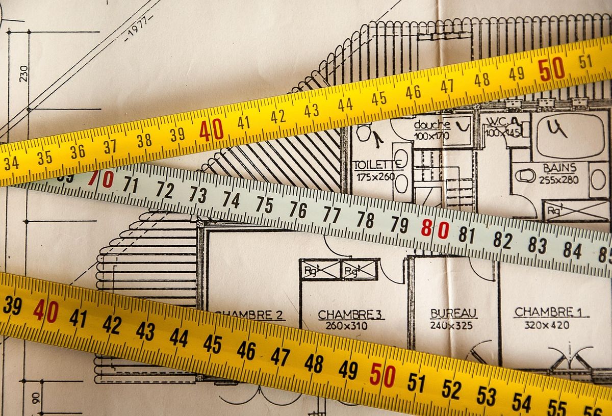 Tape measures laid across a house floor plan