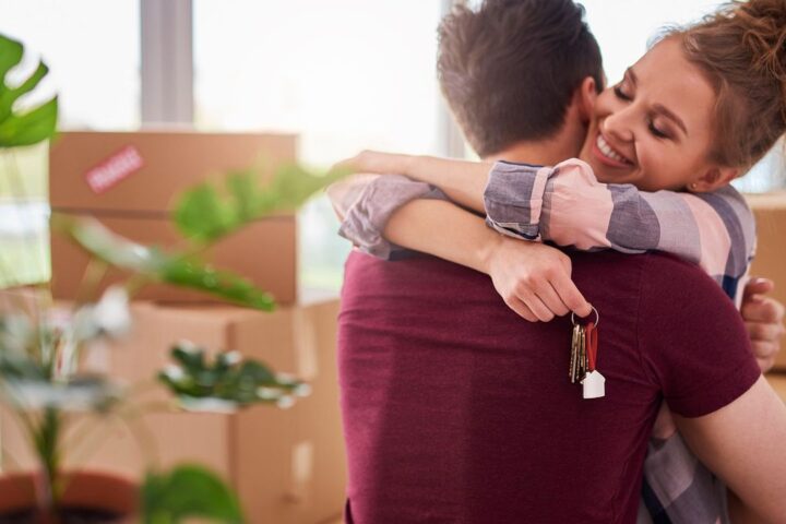 Couple hugging while holding the keys to their new home