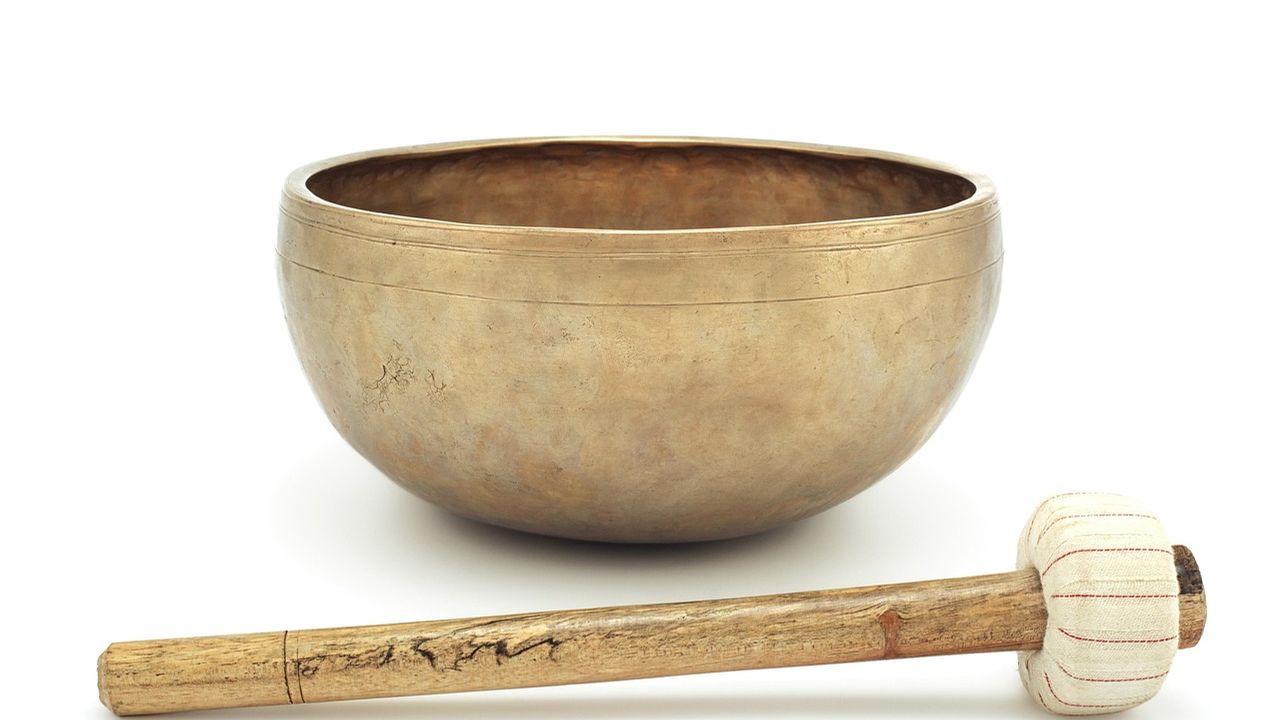 Brass singing bowl with a wooden mallet