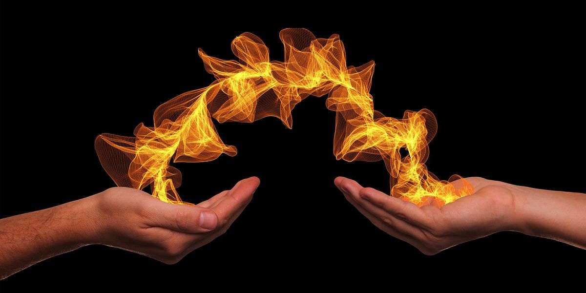 Two outstretched hands with a ribbon of flame flowing between them