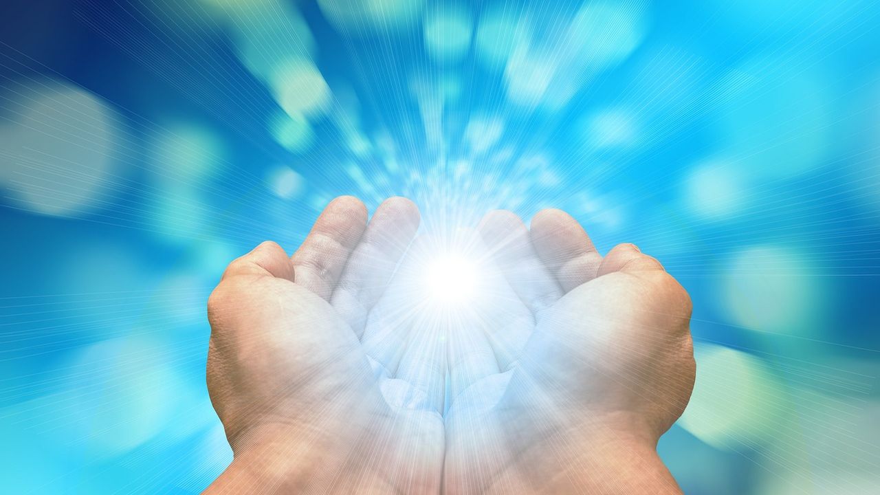 Cupped hands with a glowing burst of light between them