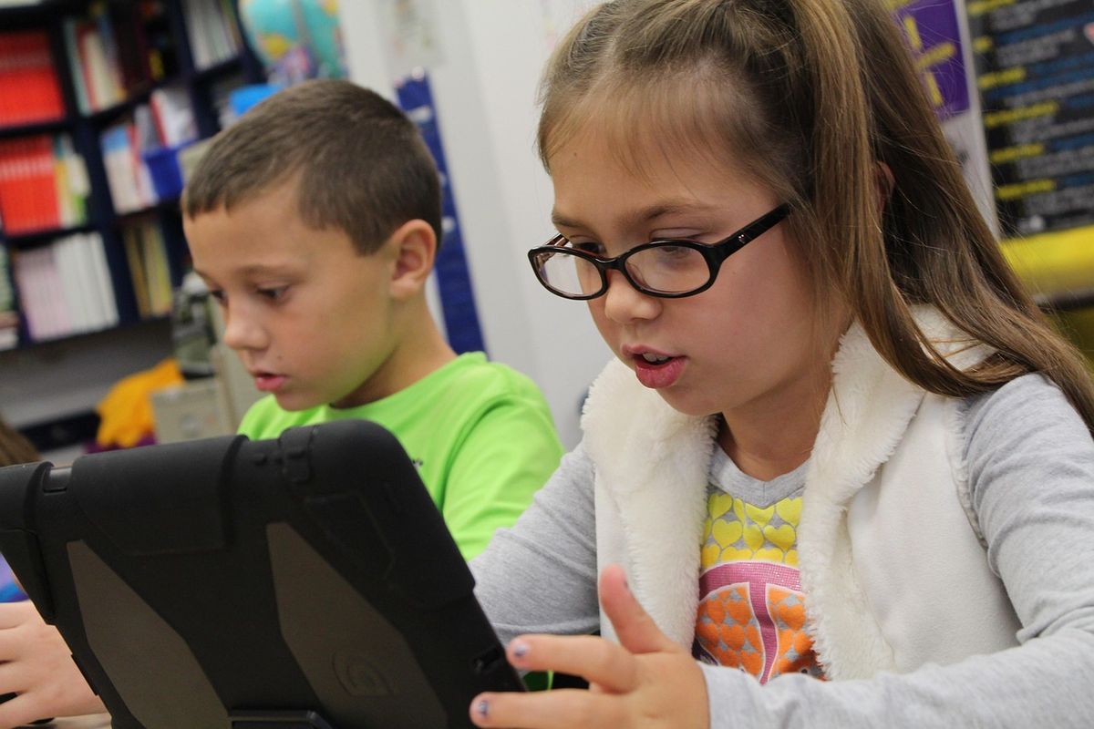 Two children using a tablet together