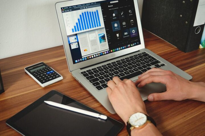 Person using a laptop showing charts at a desk