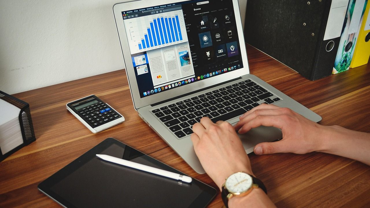 Person using a laptop showing charts at a desk