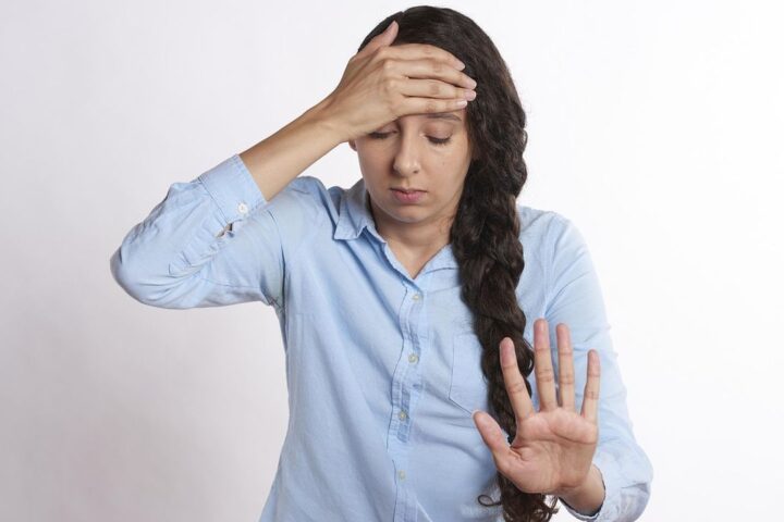Stressed woman holding her head with one hand raised