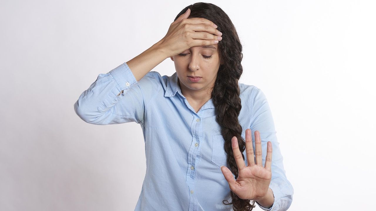 Stressed woman holding her head with one hand raised
