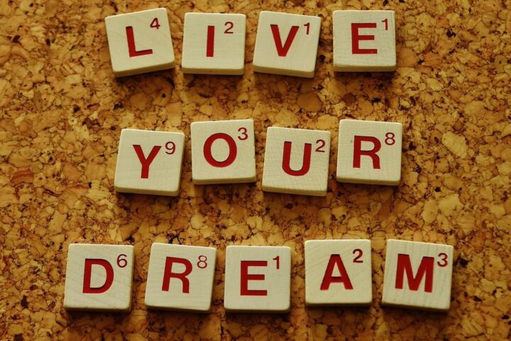 Scrabble tiles spelling Live Your Dream on a corkboard