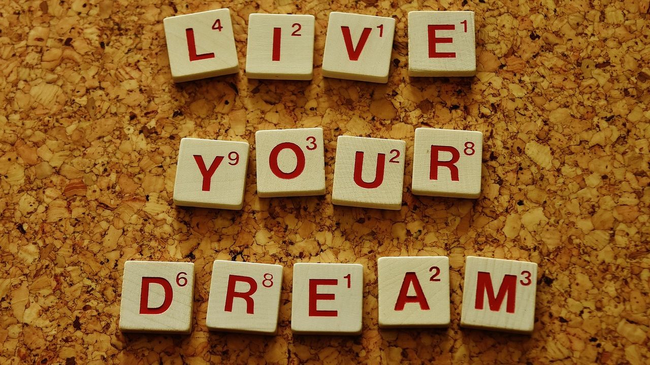 Scrabble tiles spelling Live Your Dream on a corkboard