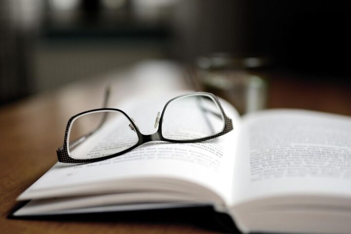 Reading glasses resting on an open book