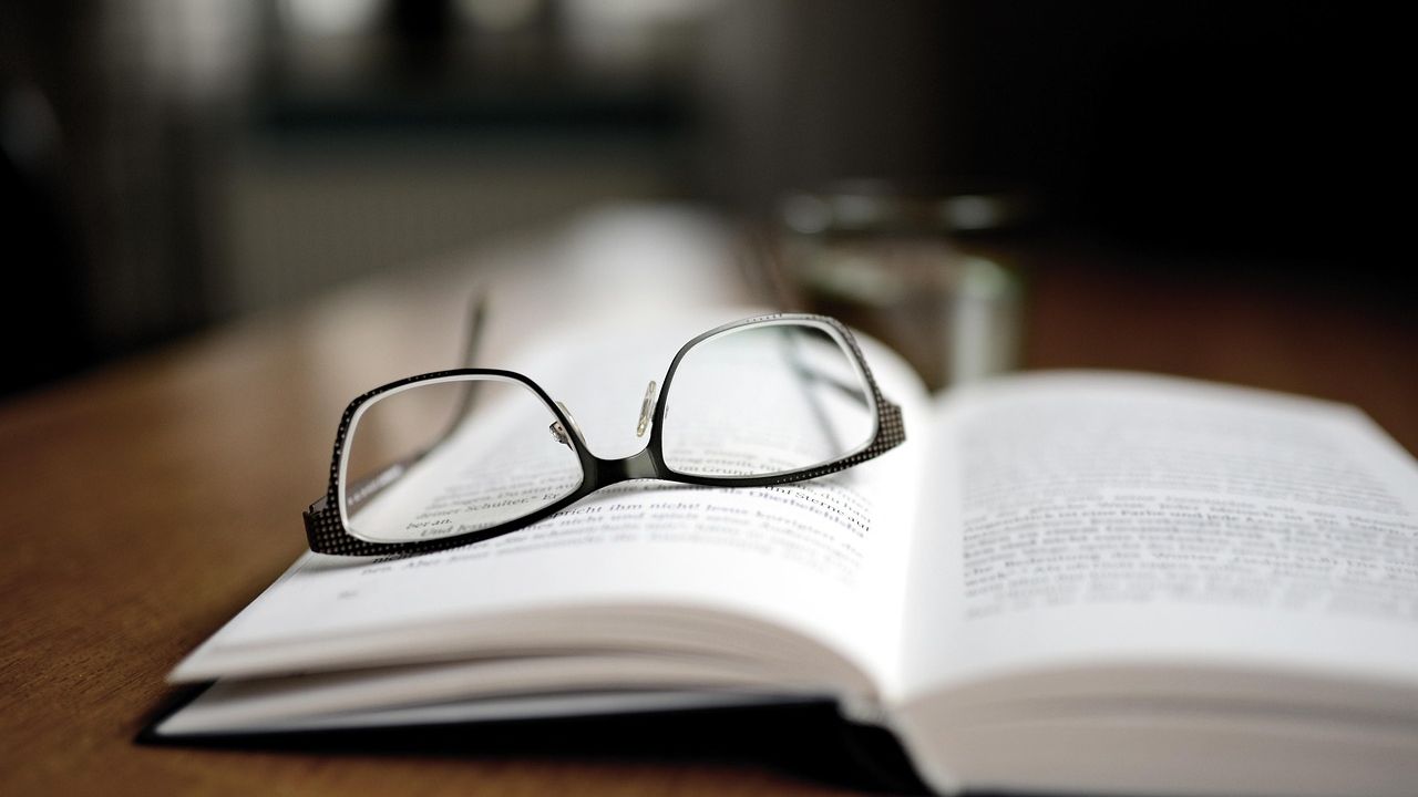 Reading glasses resting on an open book