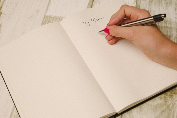 Hand writing My Plan in a blank notebook