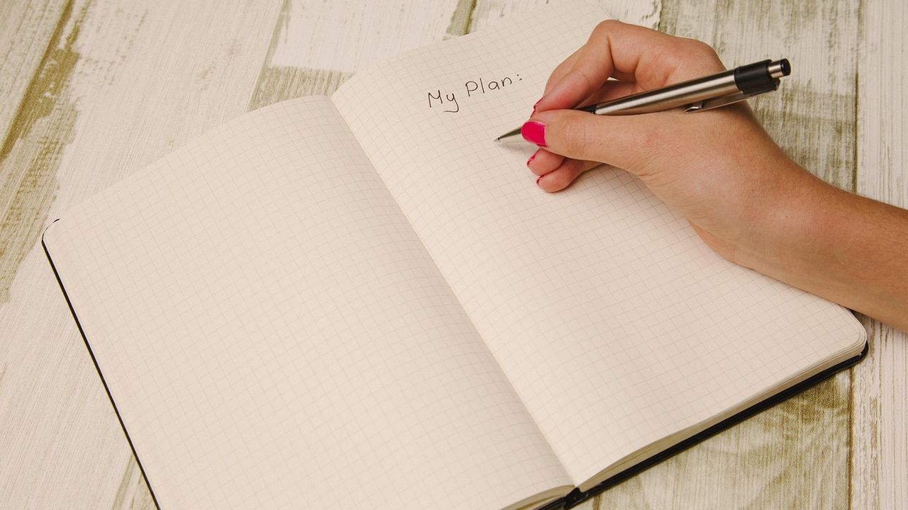 Hand writing My Plan in a blank notebook