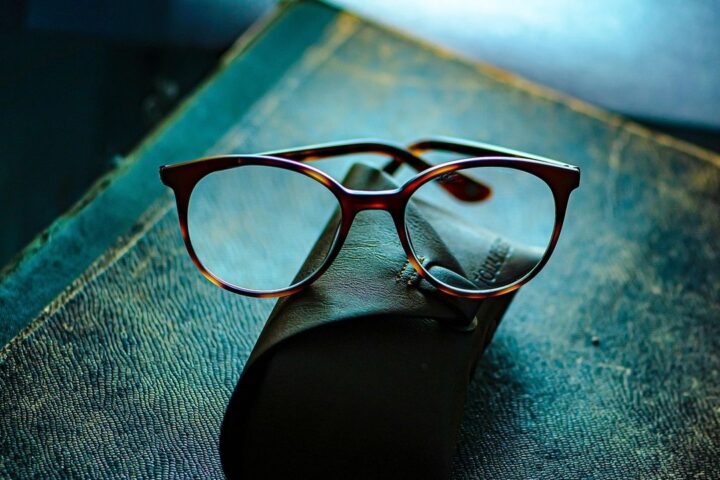 Pair of glasses on a teal surface