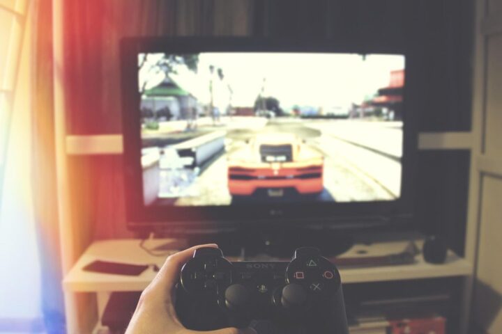 Gamer holding a controller in front of a racing game