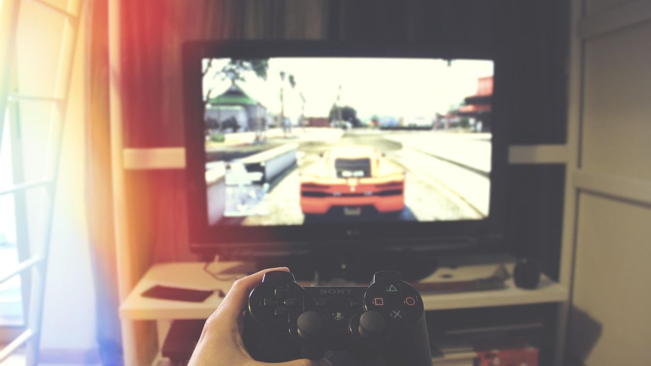 Gamer holding a controller in front of a racing game