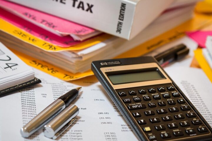 Tax paperwork, folders and a calculator on a desk