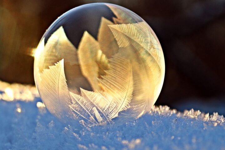 Frozen soap bubble resting on snow