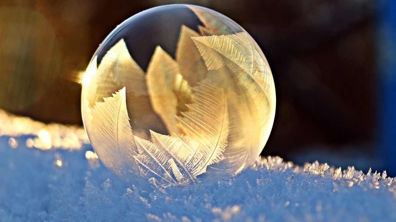 Frozen soap bubble resting on snow