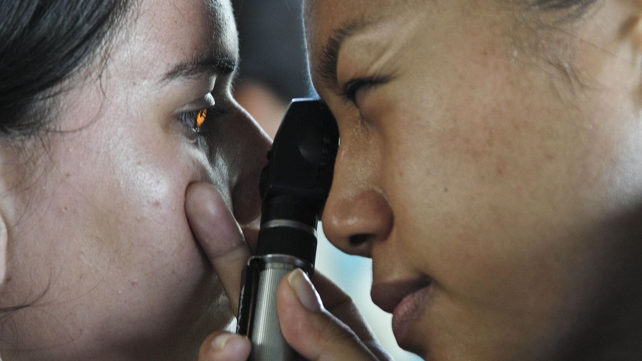 Optometrist examining a patient's eye