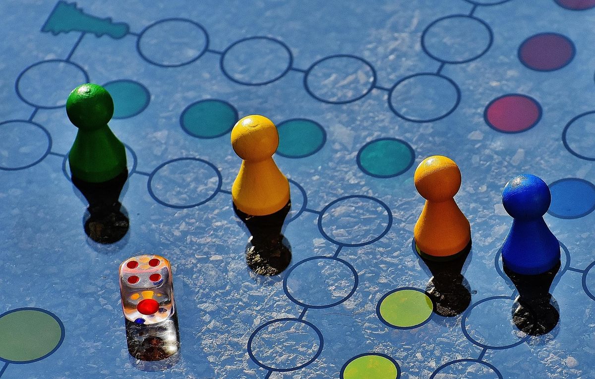 Board game pieces and dice on a colourful game board
