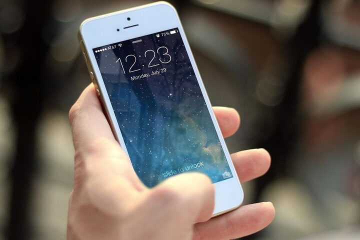 Hand holding a smartphone showing the lock screen