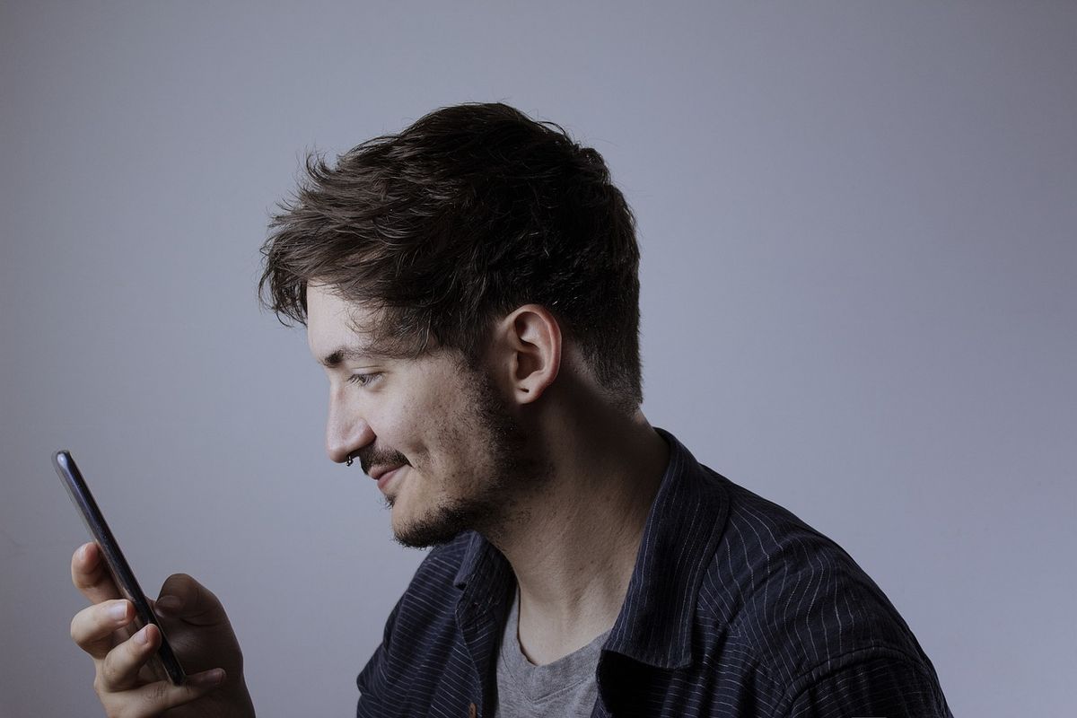 Smiling young man looking at his phone