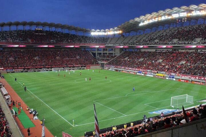 Packed football stadium under floodlights