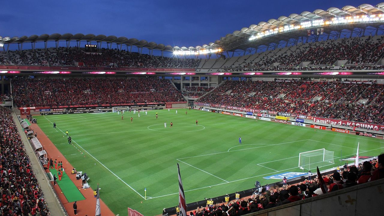 Packed football stadium under floodlights