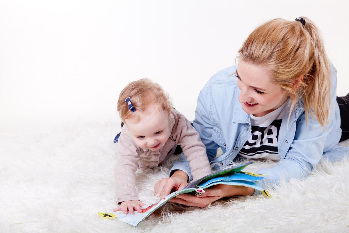 Mother and baby looking at a picture book together