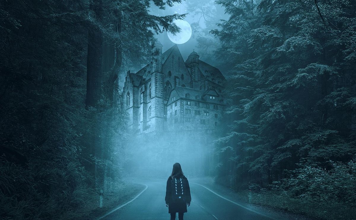 Hooded figure on a misty road before a dark mansion