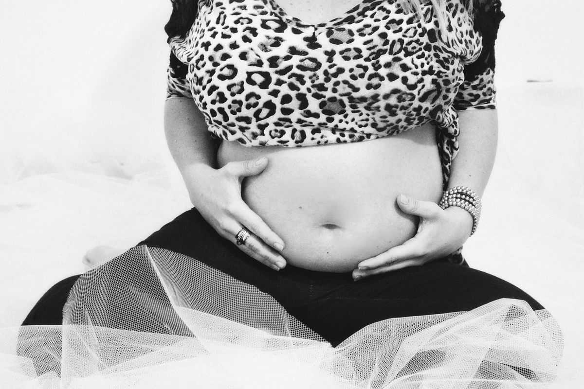 Pregnant woman cradling her bump