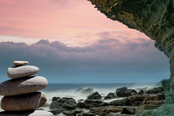 Stacked stones on a rocky shore at dusk