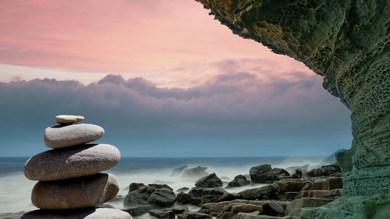 Stacked stones on a rocky shore at dusk