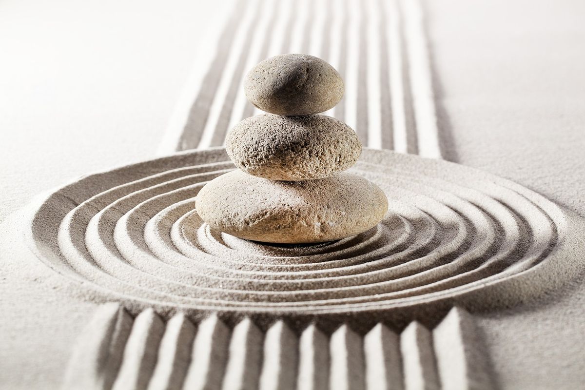 Balanced stones on raked sand in a zen garden