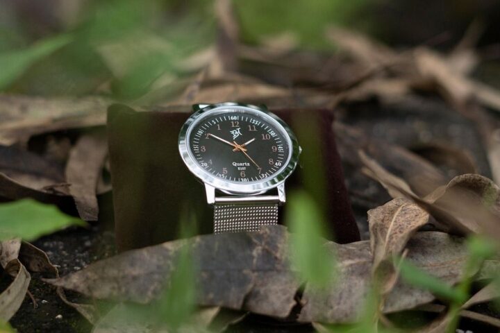 Men's wristwatch with a steel mesh strap among autumn leaves