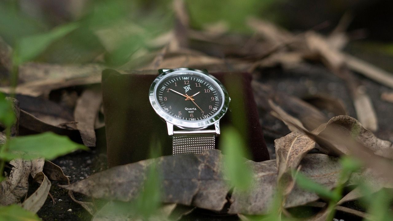 Men's wristwatch with a steel mesh strap among autumn leaves