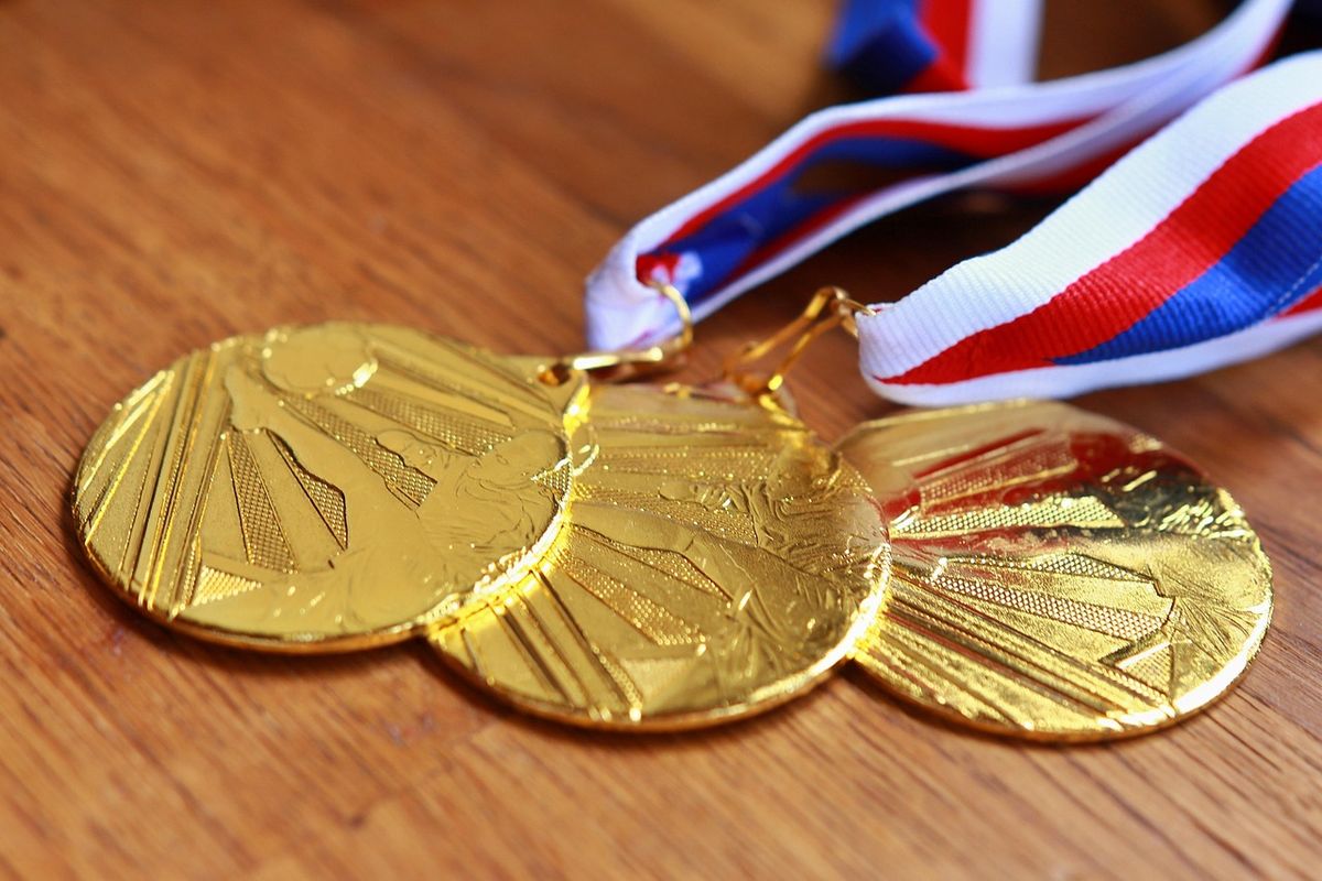 Gold medals with striped ribbons on a wooden table