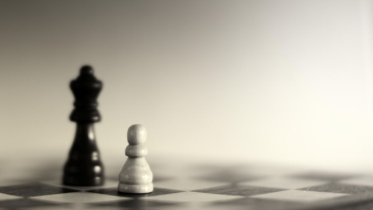 Chess king and pawn on a board, suggesting tactics