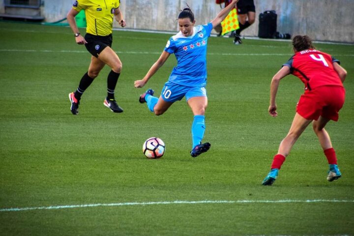 Women footballers competing for the ball during a match