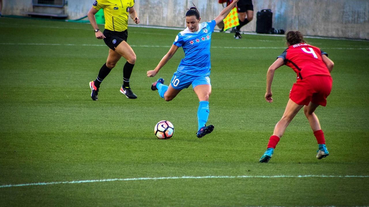 Women footballers competing for the ball during a match