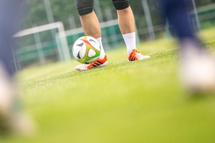Player striking a football on a training pitch