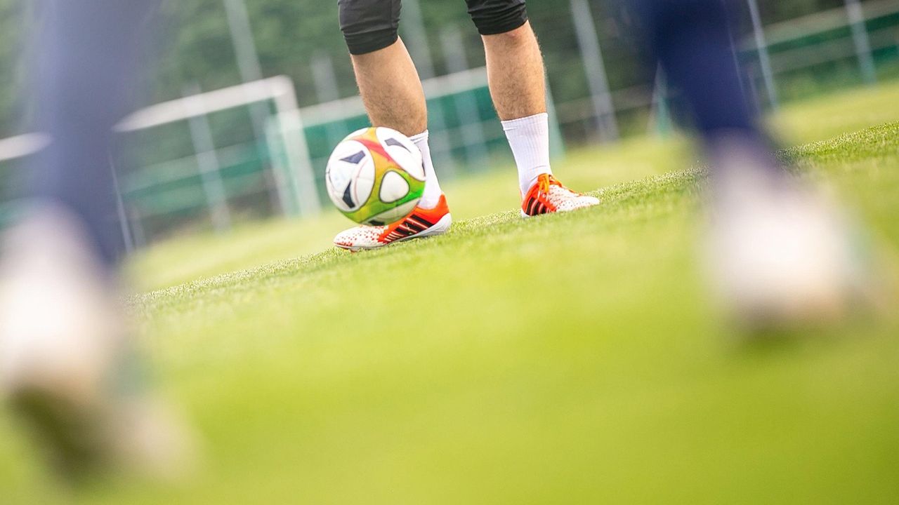 Player striking a football on a training pitch