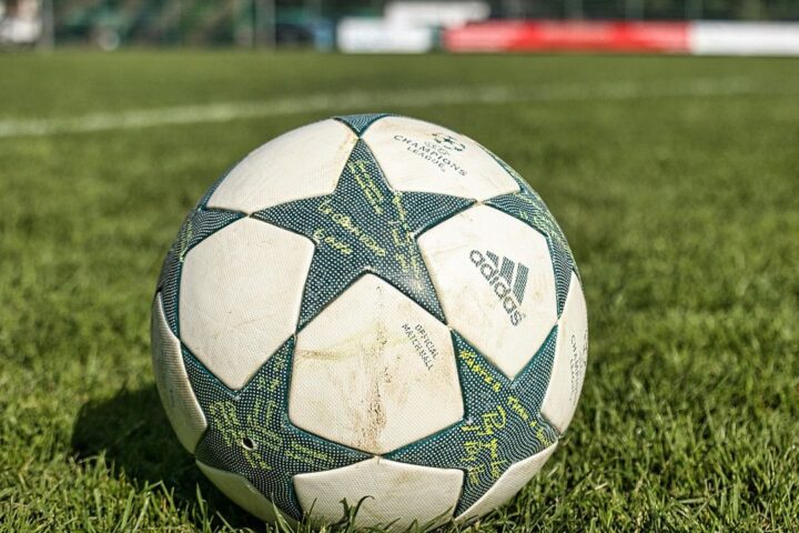 Star-patterned football resting on a grass pitch
