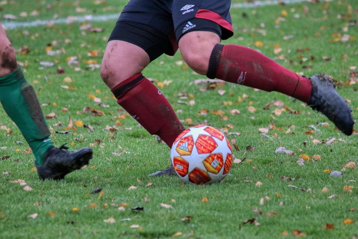 Footballer in red socks striking the ball