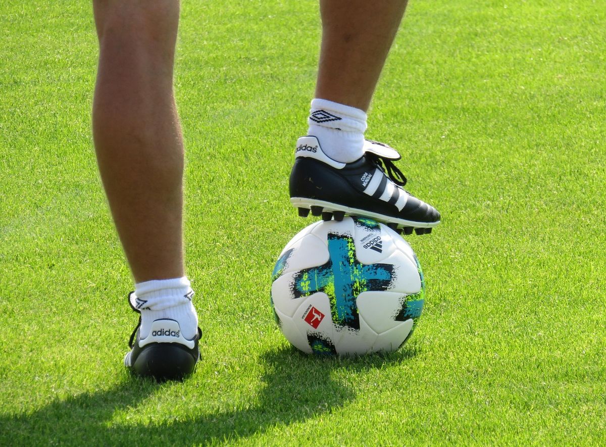 Player resting a boot on top of a football