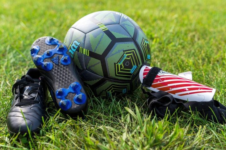 Football boots, shin pads and a ball on the grass