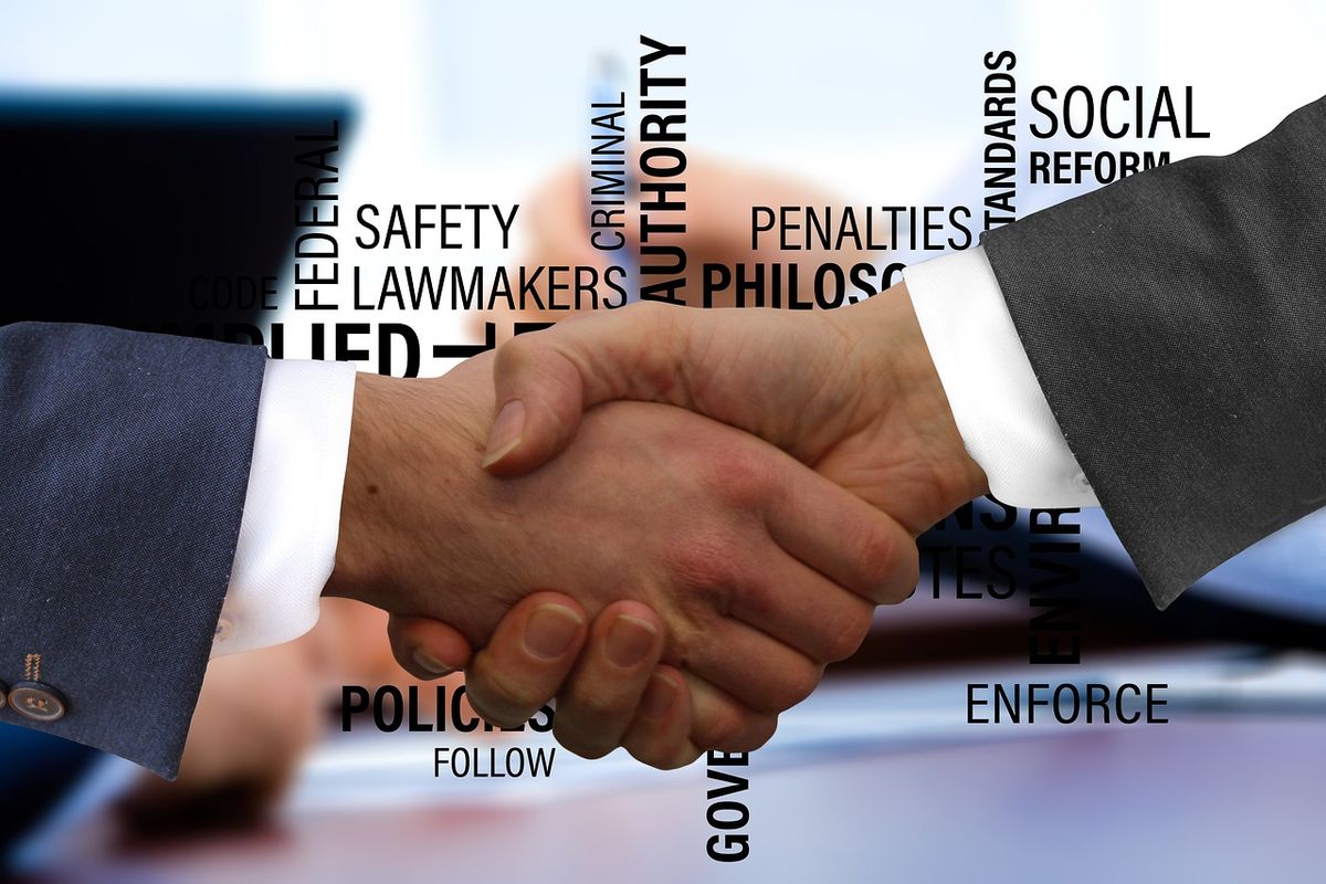 Handshake in front of legal and regulatory words