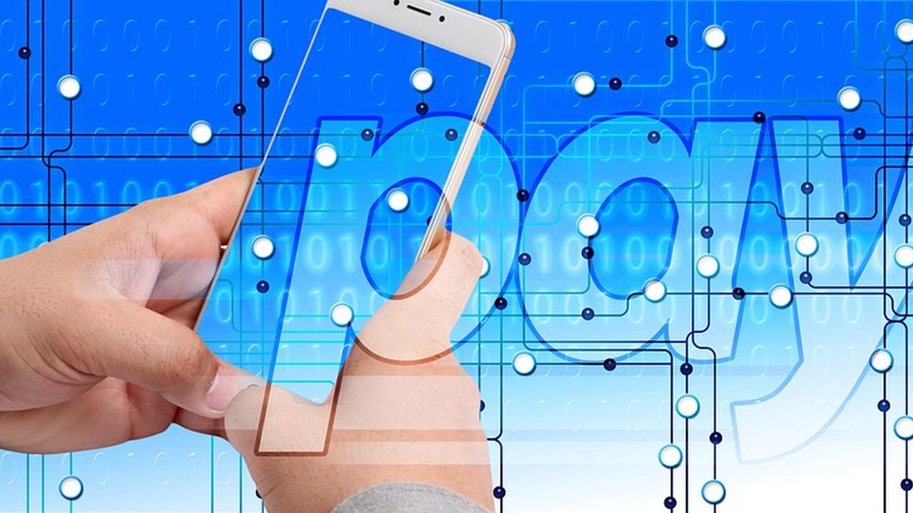 Hand holding a phone in front of a digital payment graphic