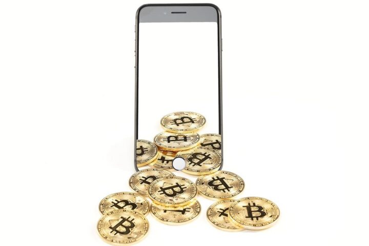 Pile of bitcoin coins spilling out of a smartphone