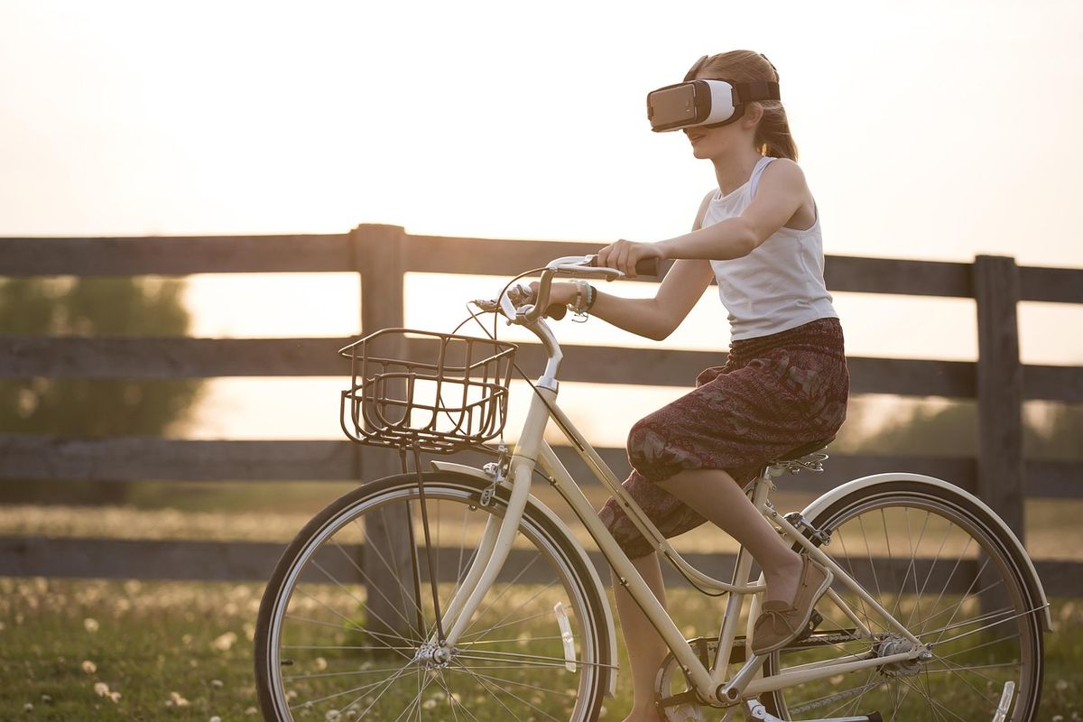 Woman wearing a VR headset while riding a bicycle